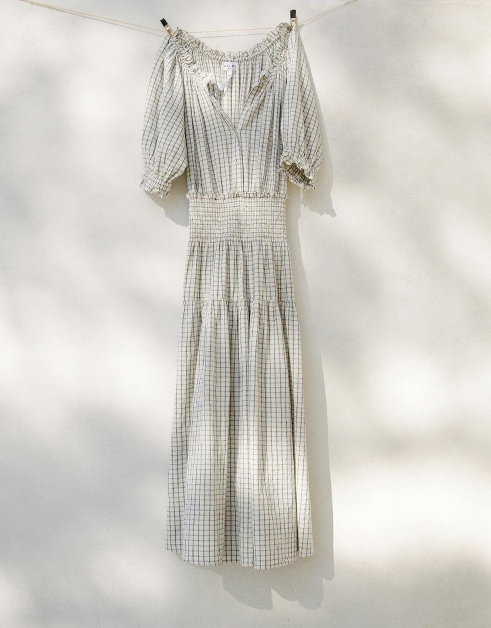 A white patterned dress hangs from a drying line