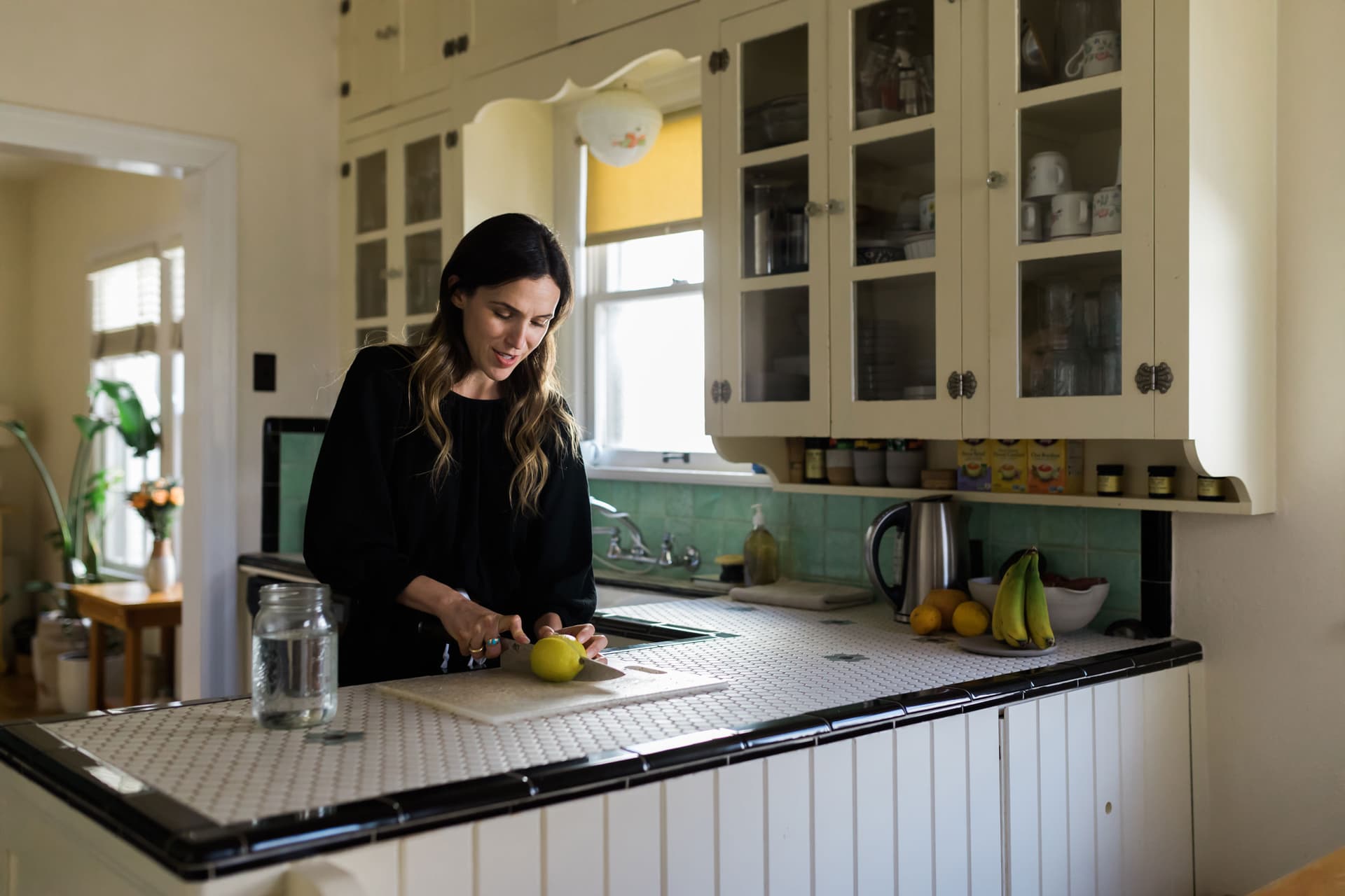Adriene Mishler stands behind a counter wearing a dark outfit