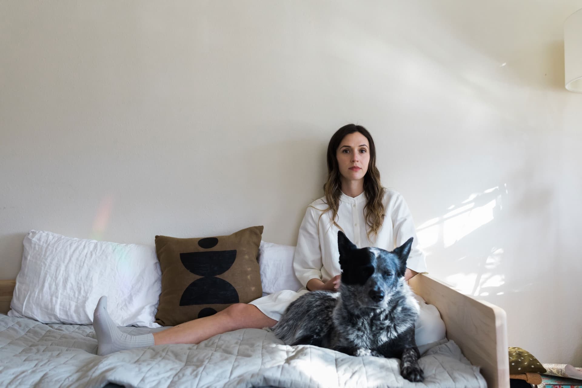 Adriene Mishler sits on a bed