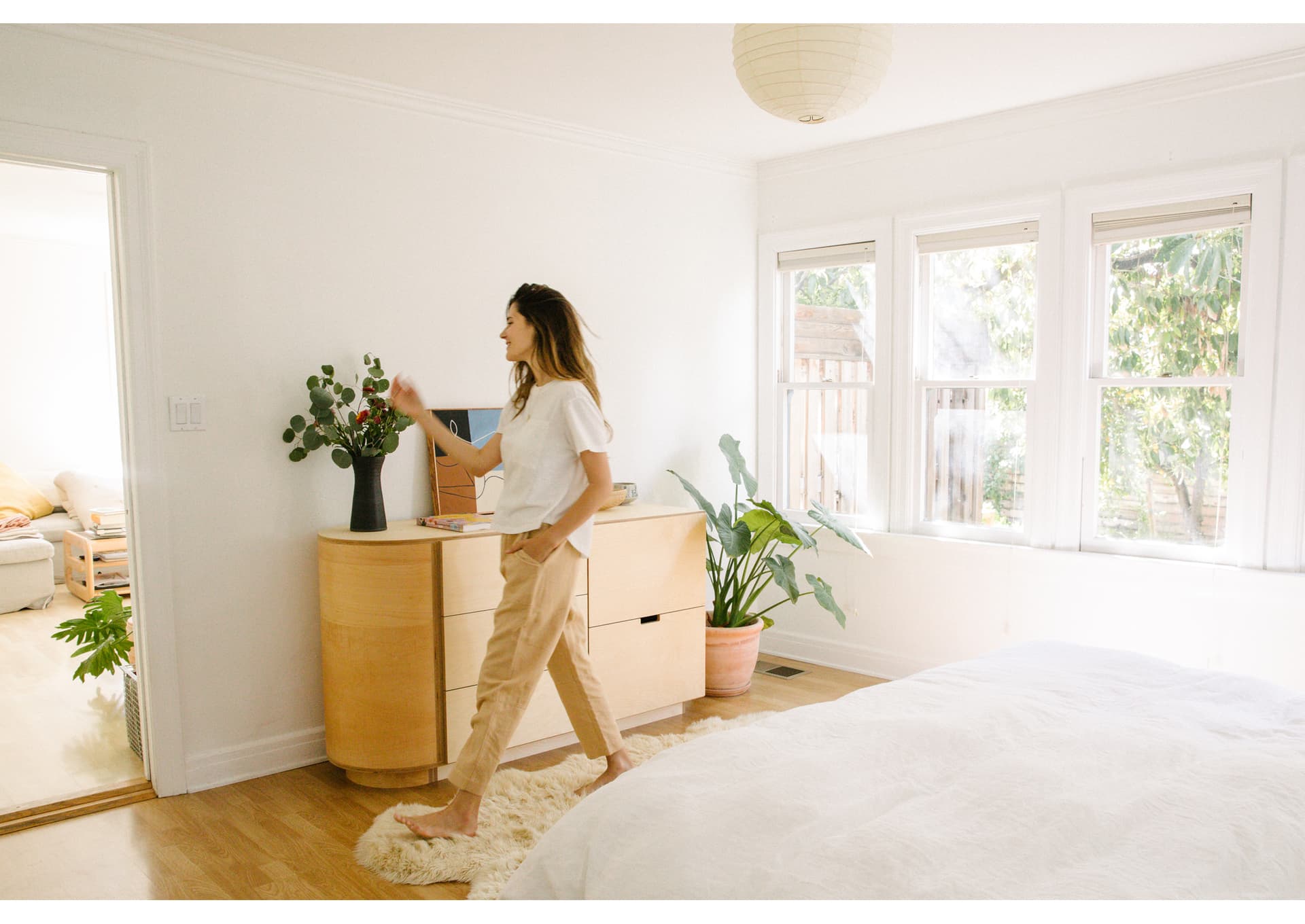 Ally Walsh wears light colors and walks in a white, well lit room