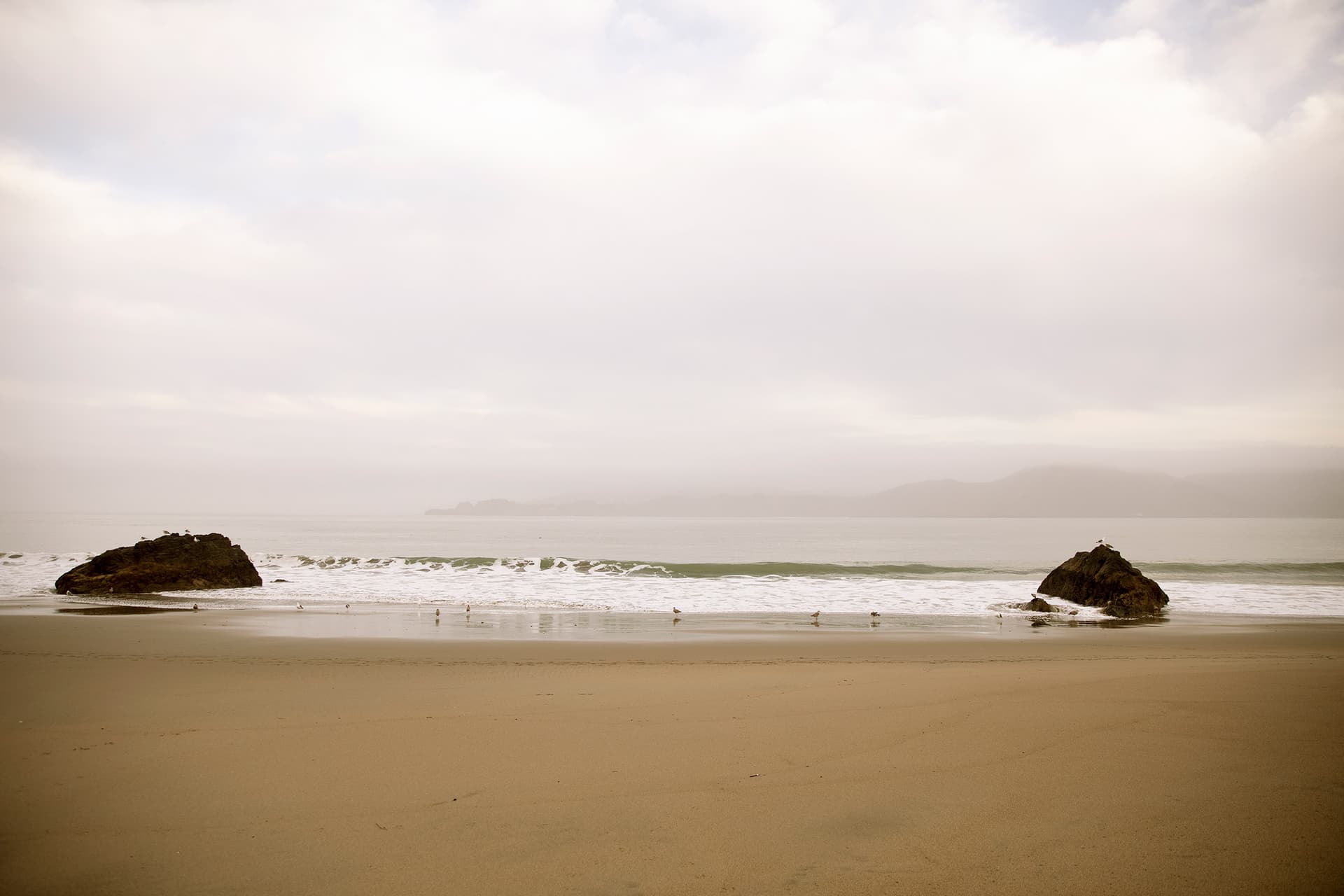 A peaceful image of an empty beach and calm water