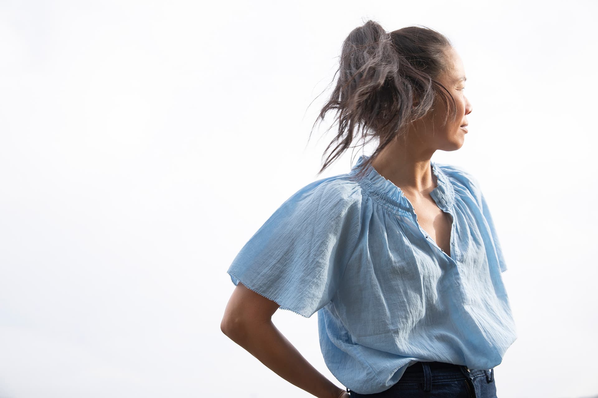 Bonnie Tsui standing away from the camera and wearing a blue blouse