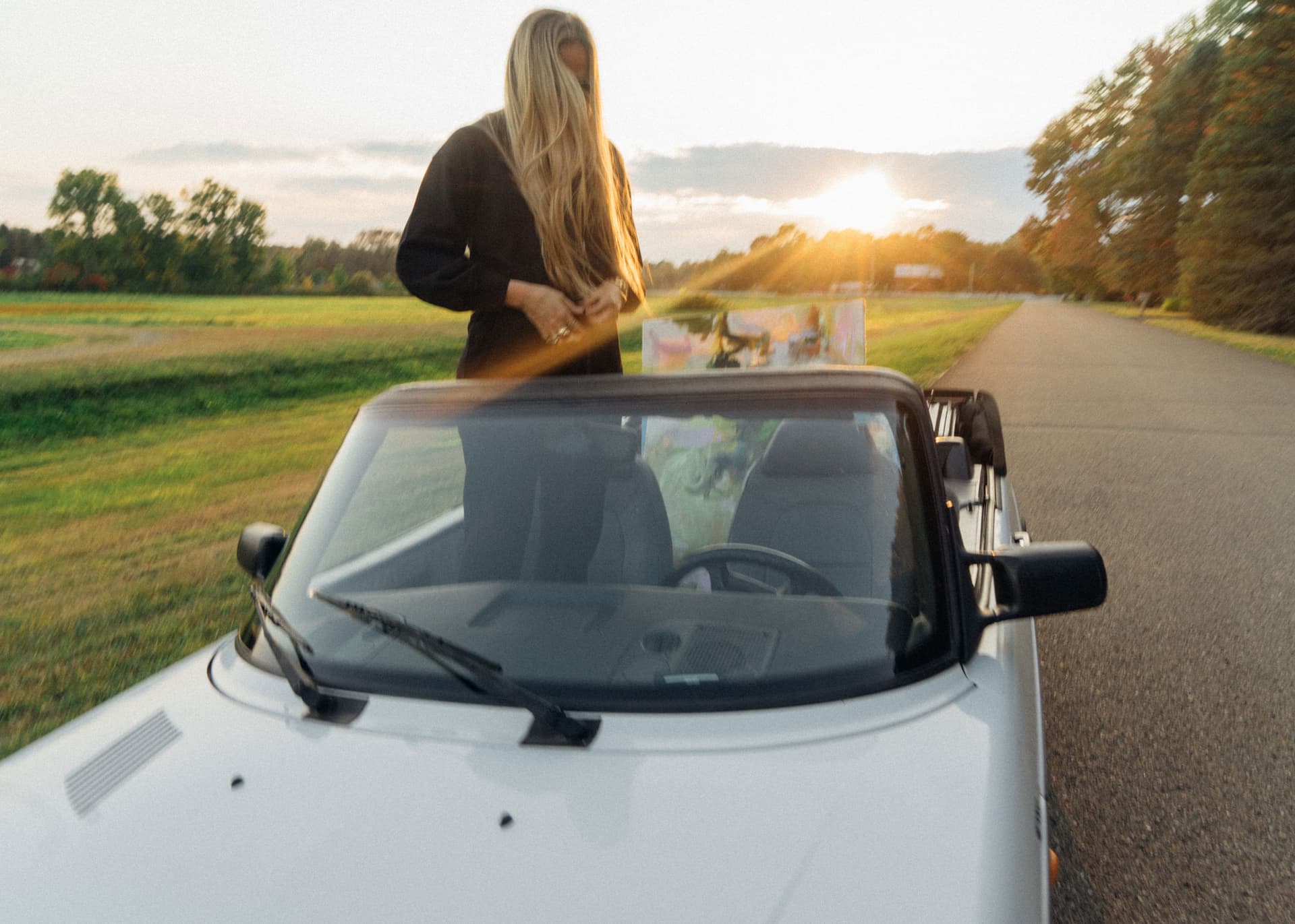 A woman stands up in a car