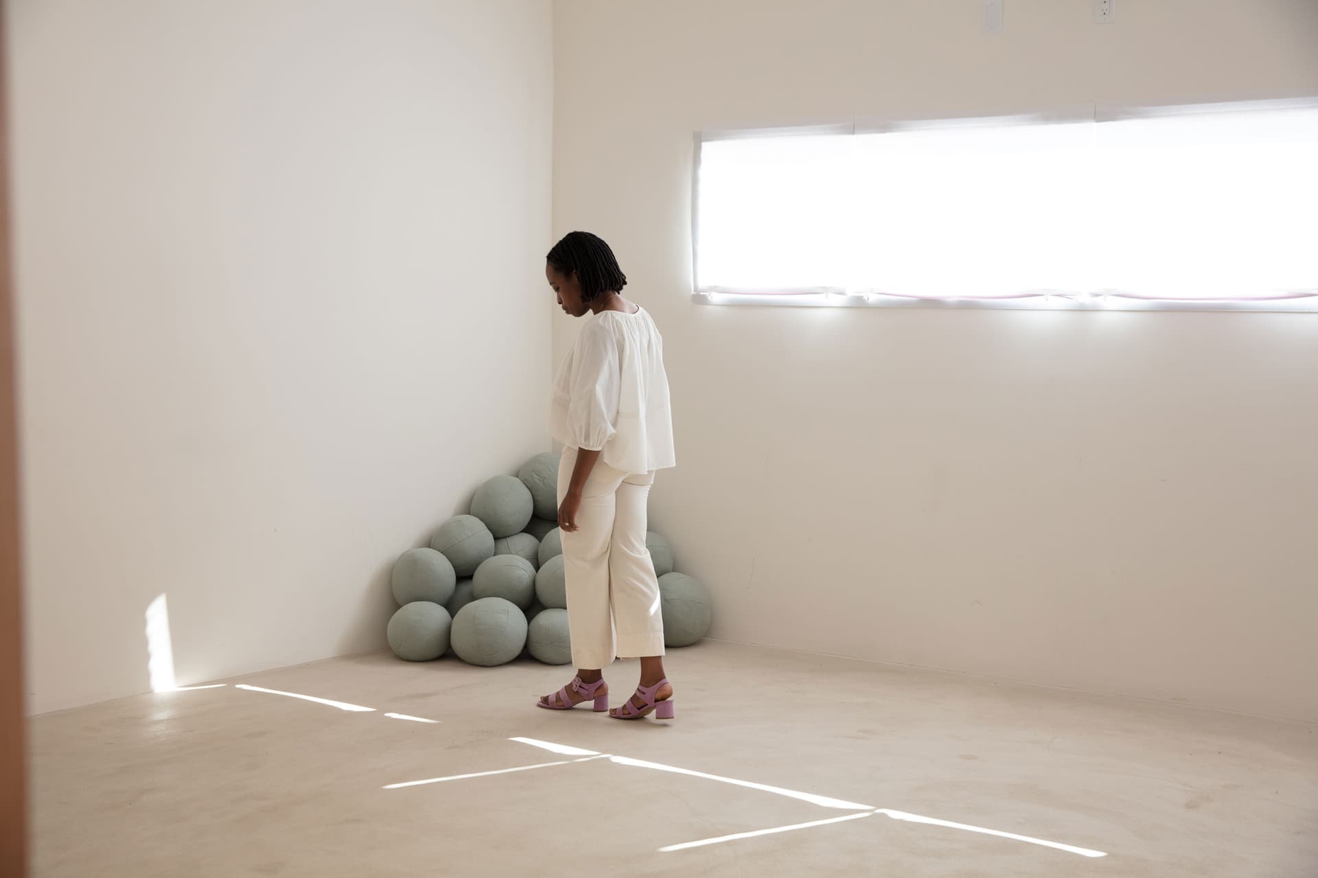 Erica Chidi Cohen wears white and stands in a clean well-lit room