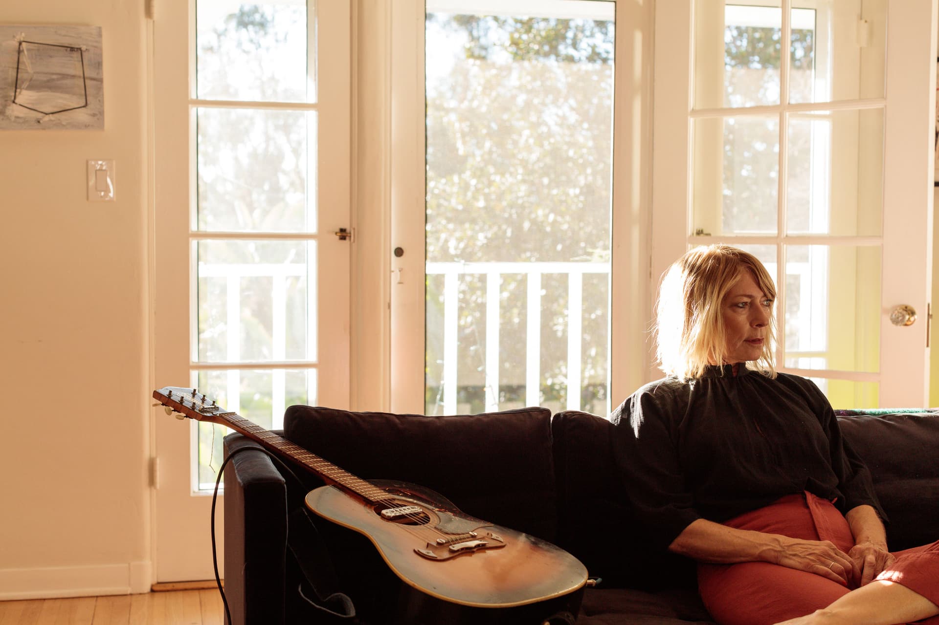 Kim Gordon sits next to a guitar