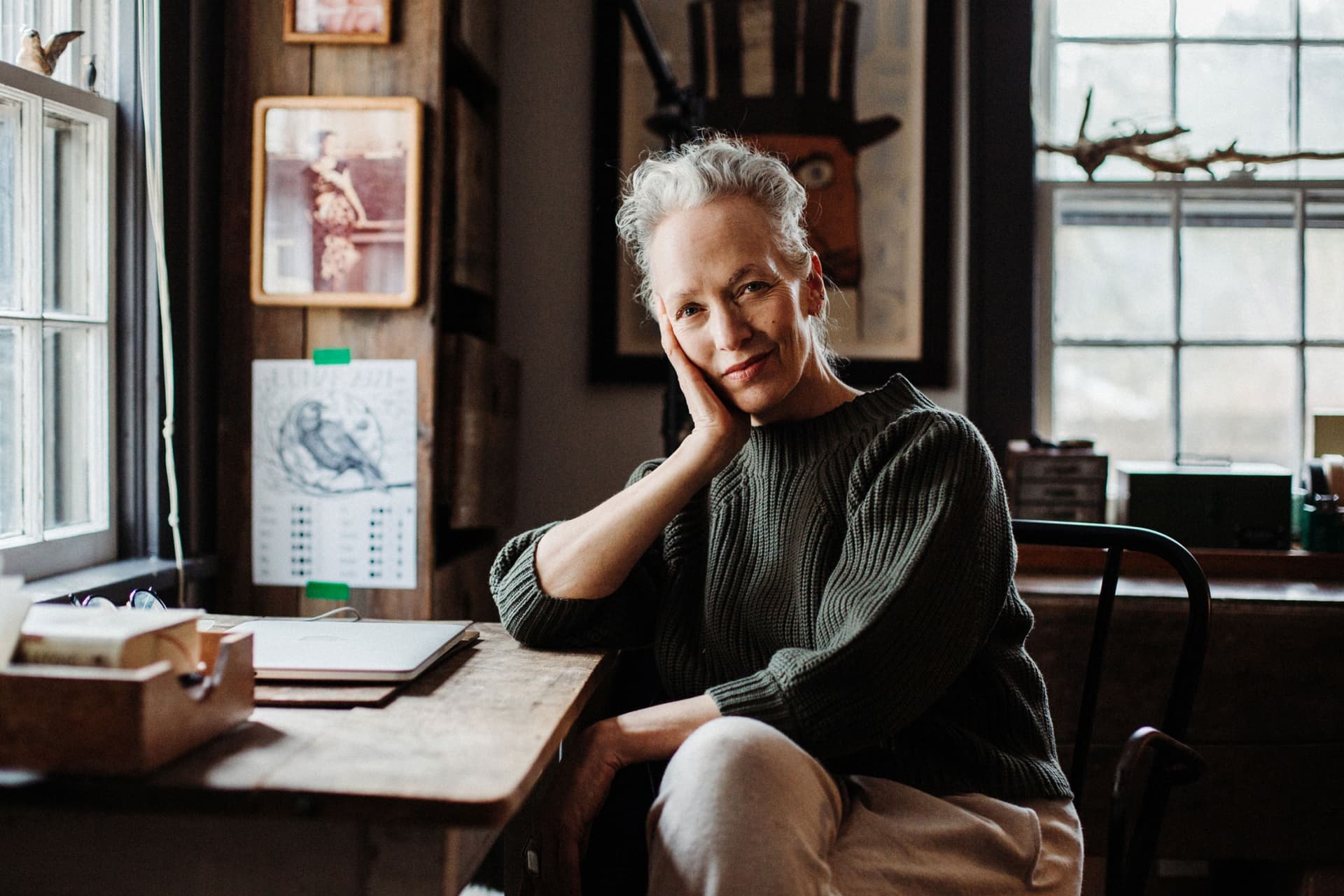 Laura Silverman wears a dark top and sits at a desk