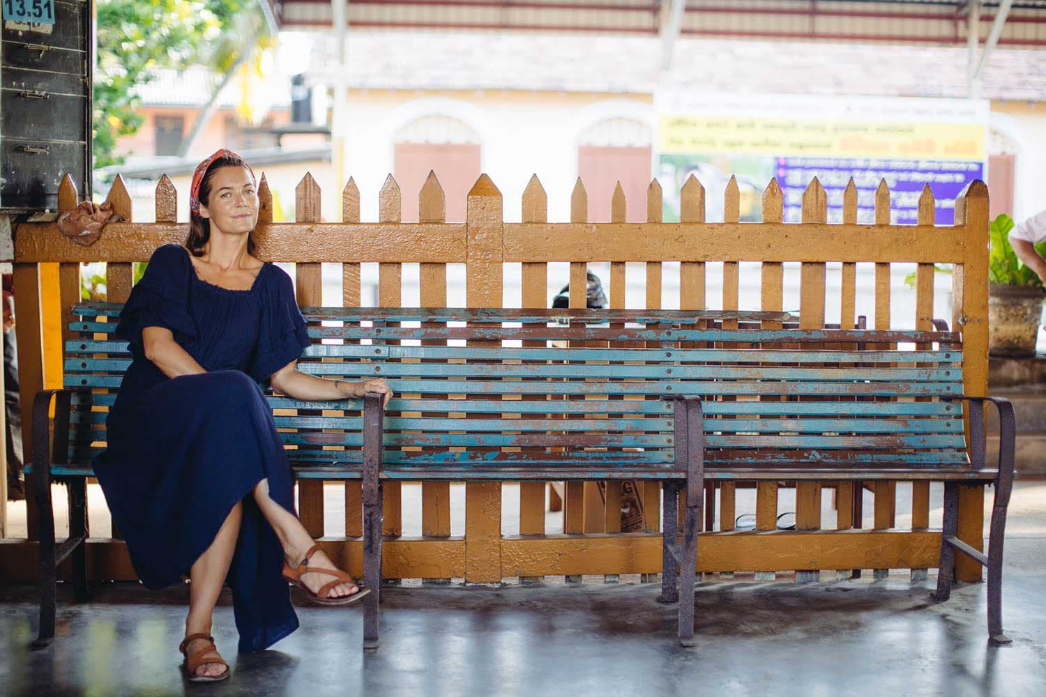 Taryn Elledge-Penner wears a dark outfit and sits on an outside bench.