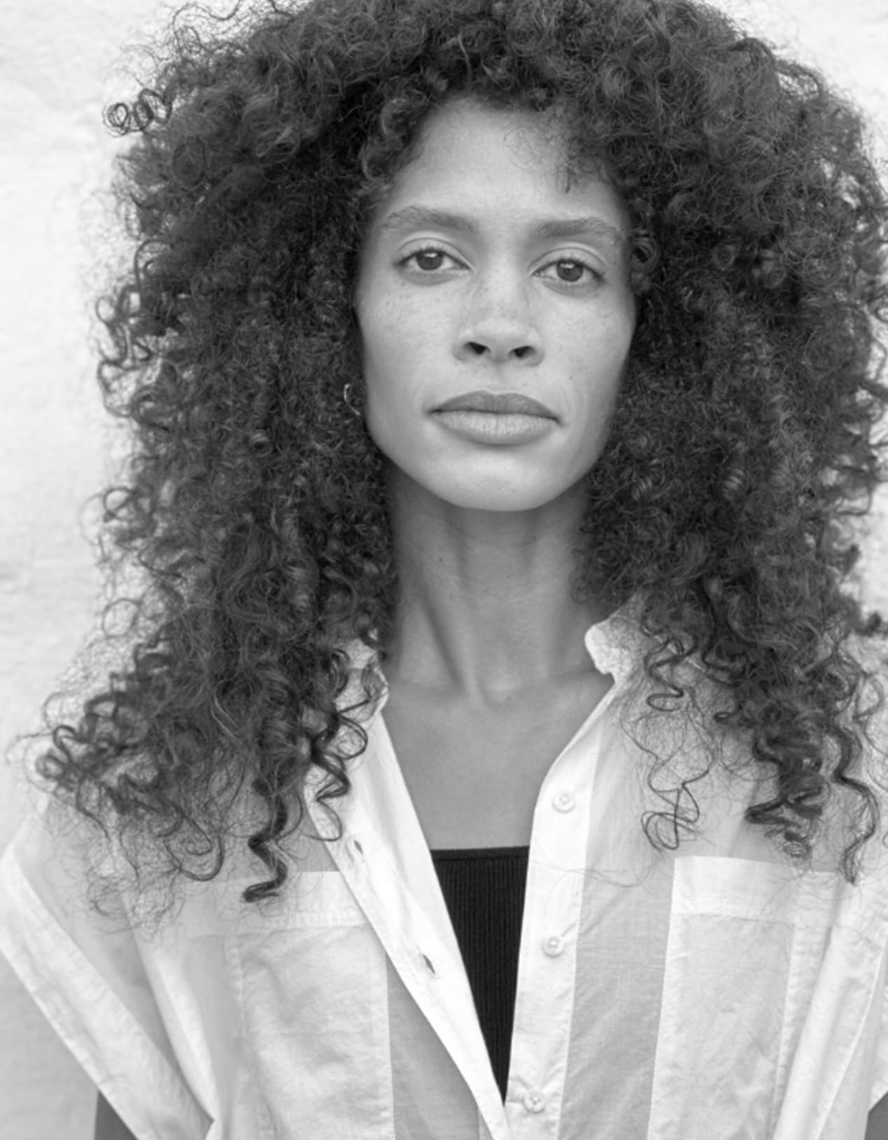 A black and white image of a woman in a white top