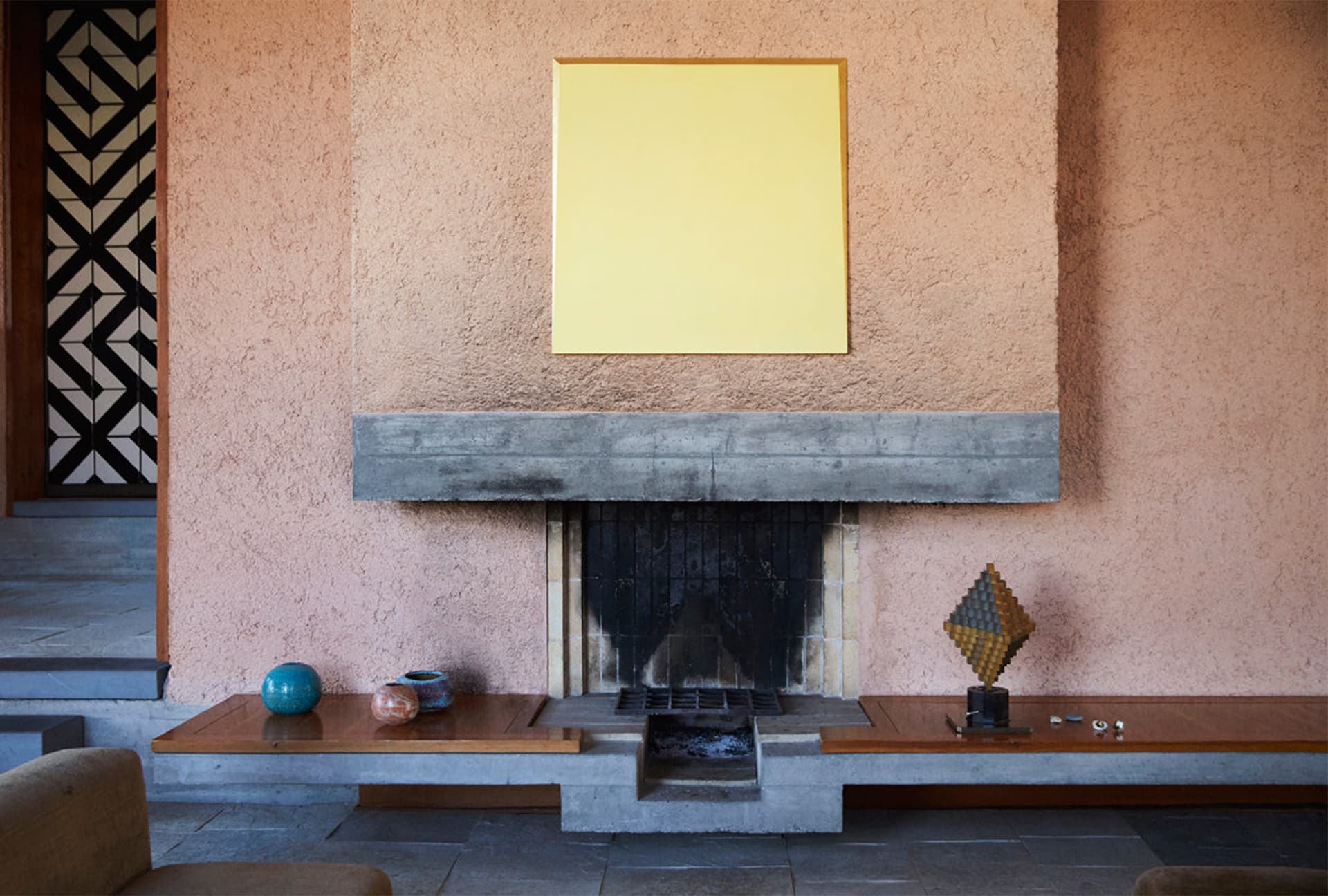 An image of a fireplace in a pink wall.